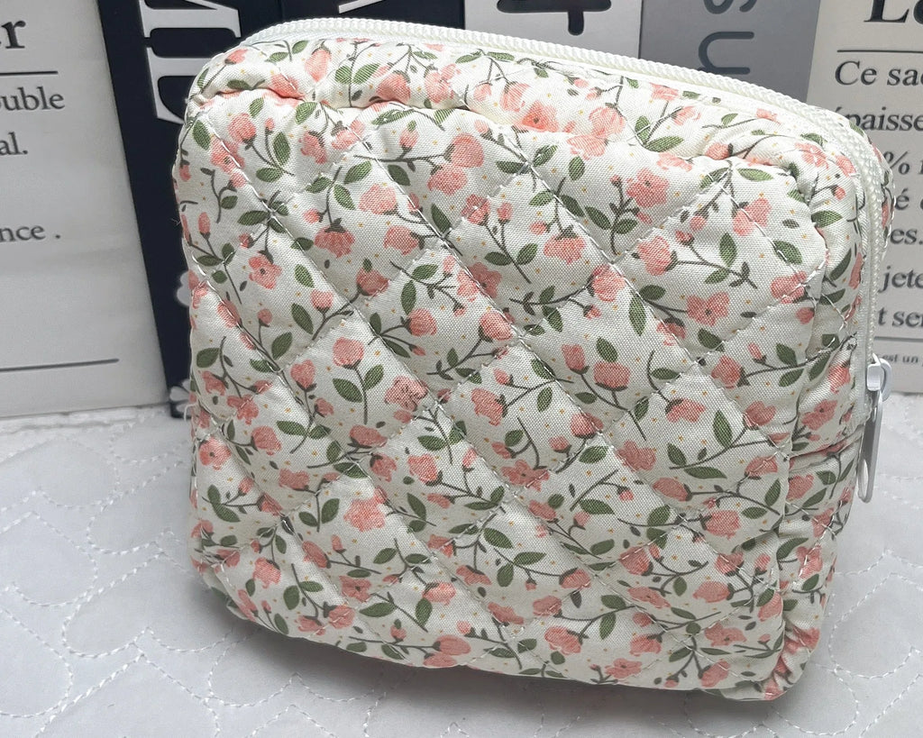 Yellow floral polyester key storage bag with sewing thread detail next to red small flower design variant.