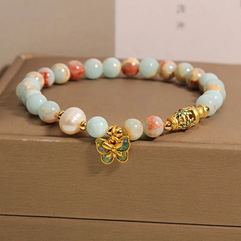 Shoushan stone and freshwater pearl bracelet with blue butterfly pendant on display