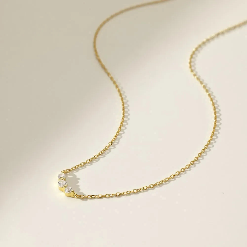 Geometric zircon pendant necklace in 925 silver with gold electroplate finish on display