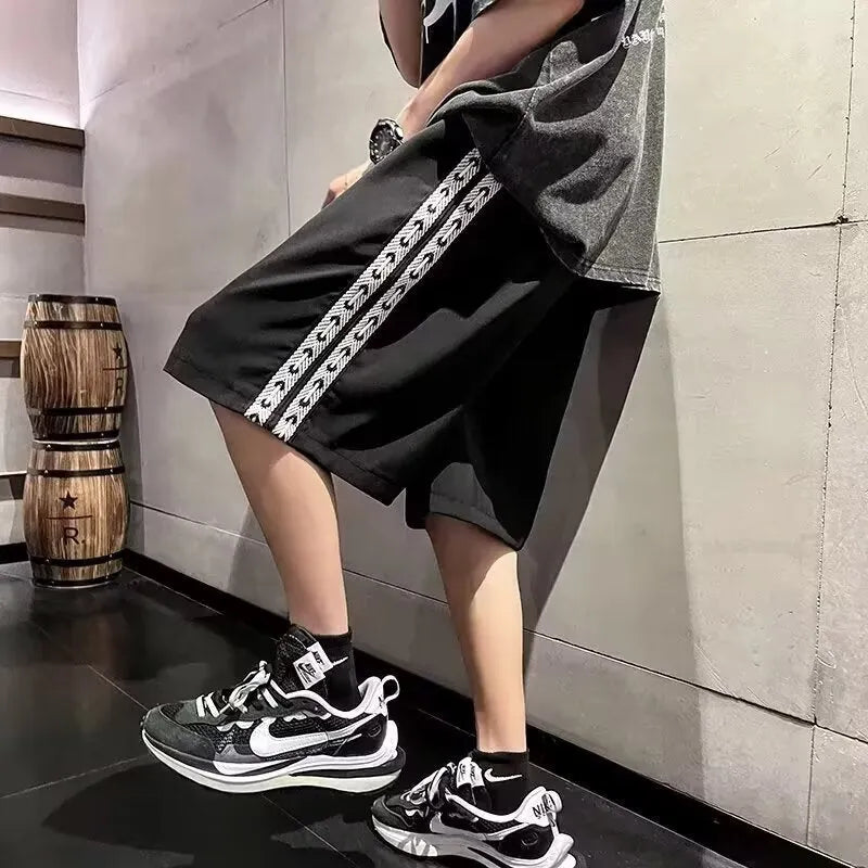 Men's loose black track pants with elastic waistband and baggy leg fit