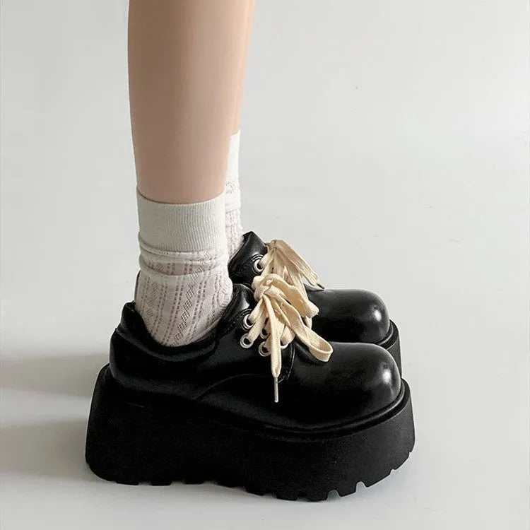 Women's matte black lace-up shoes with a high muffin heel and thick rubber sole.