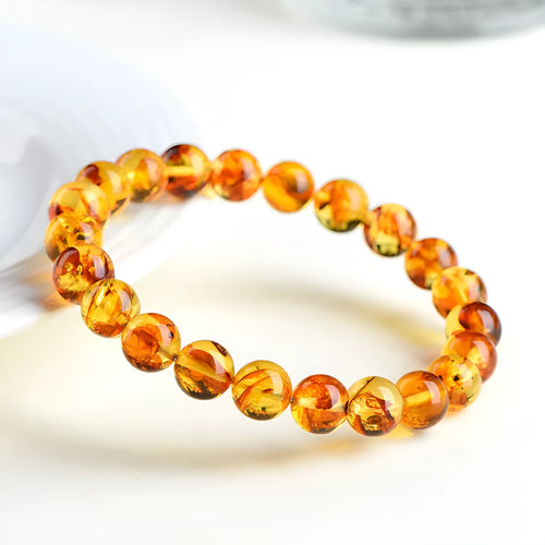 Yellow piebald amber bracelet with geometric beads showing natural flower spot patterning