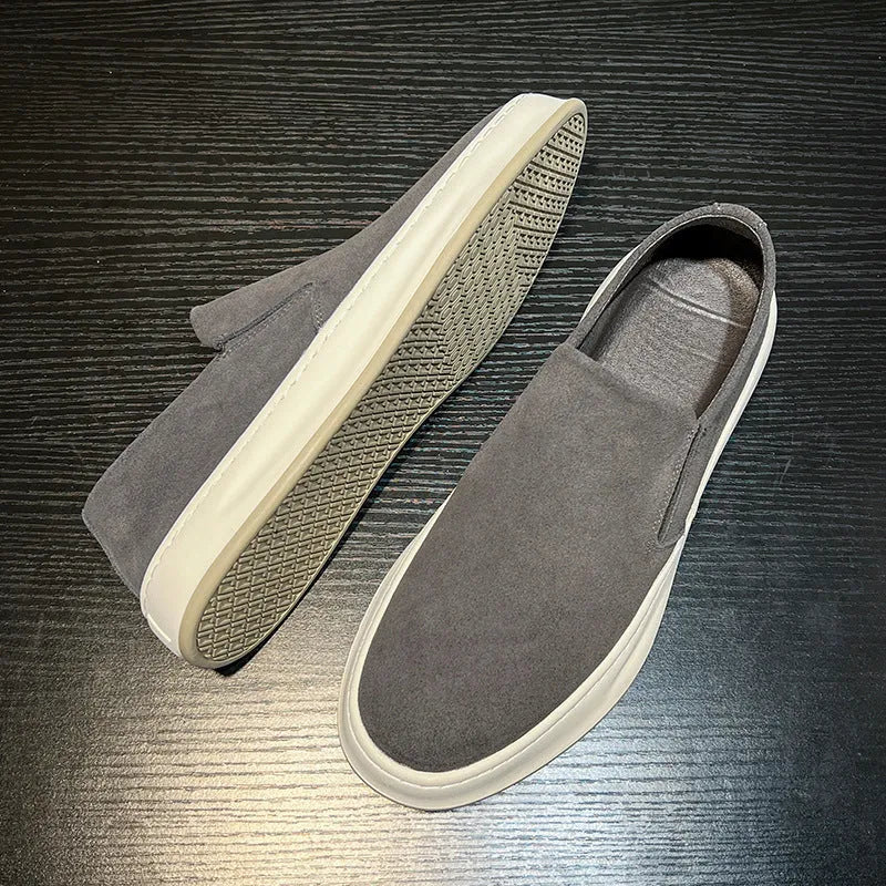 Men's grey slip-on casual shoes with round toe design and visible stitching details