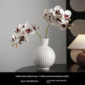 White ceramic ball vase with striped patterning in American country style on wooden table