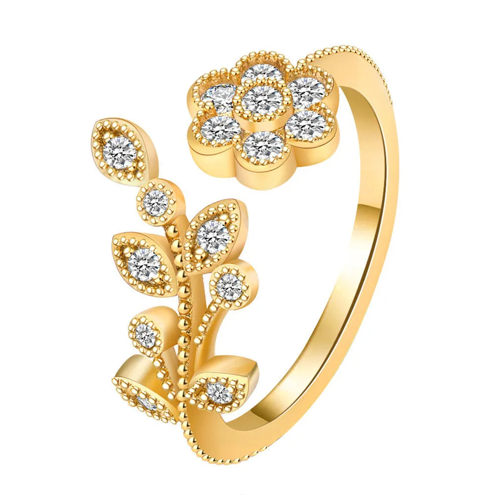 Women's open ring with floral leaf design in gold tone on white background