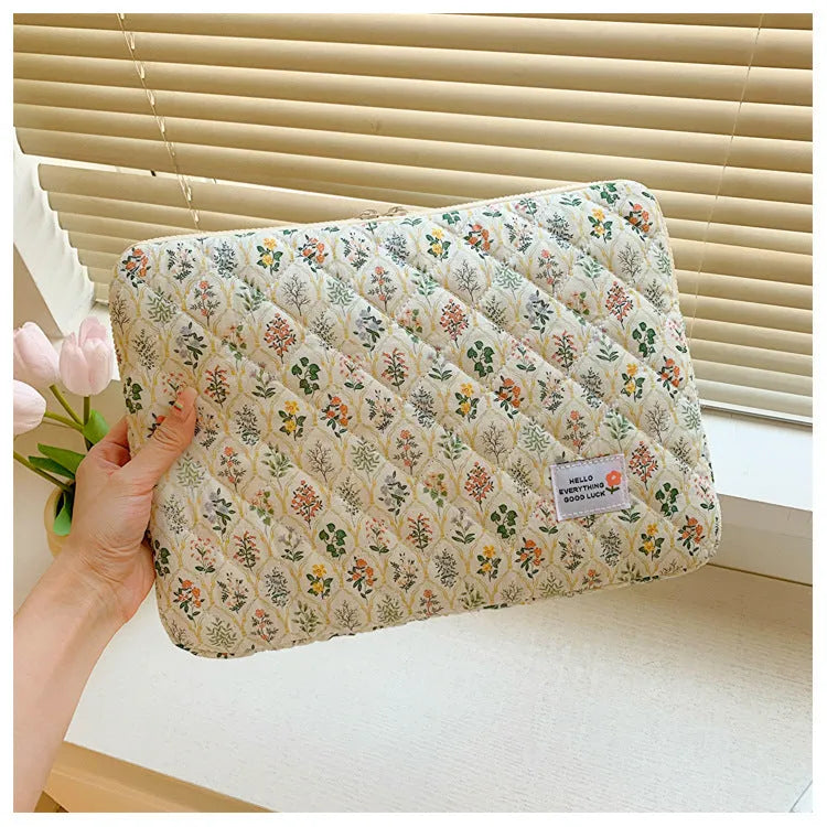 Floral print cloth laptop bag in green flower, pink floral, red flower, and red heart designs, showing three size options.