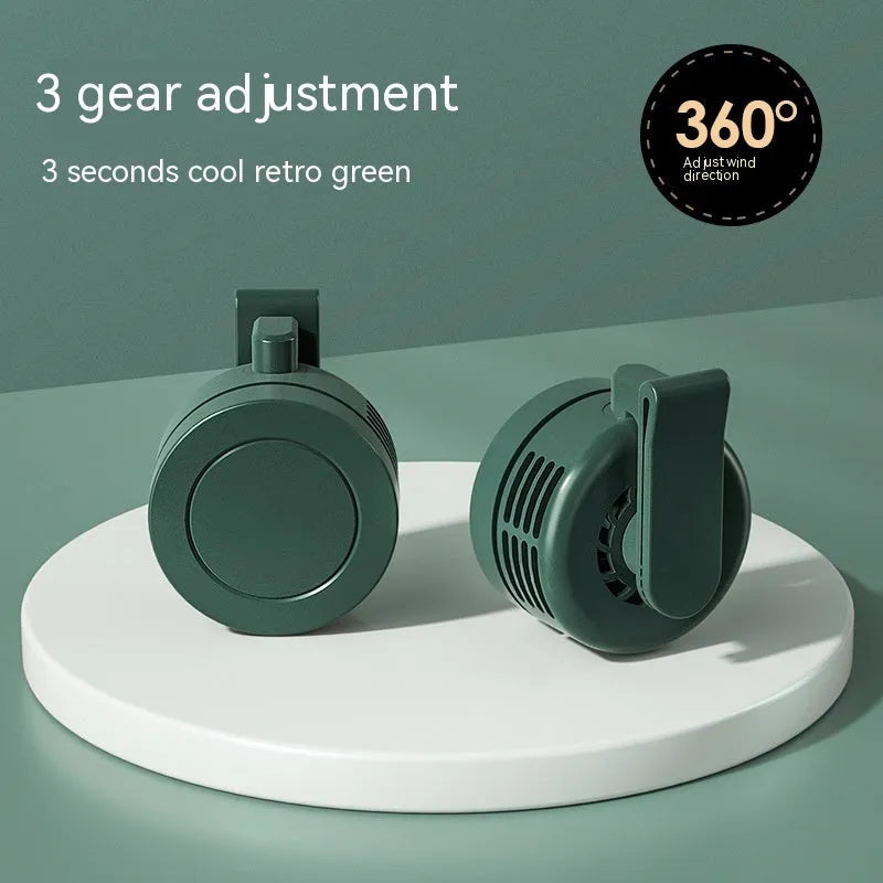 Green wearable wrist fan with LED light and USB charging port, showing adjustable strap.