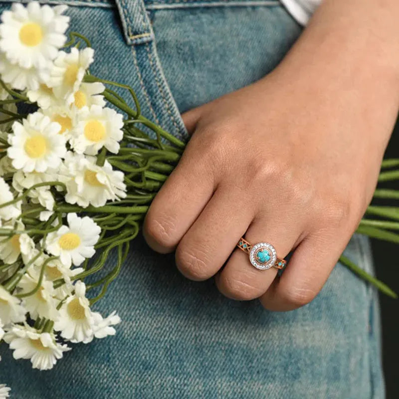 Women's rose gold copper ring with geometric design and inlaid turquoise-style zircon stones.