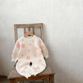 Baby romper jumpsuit in cotton with long sleeves, pink flowers pattern, side view