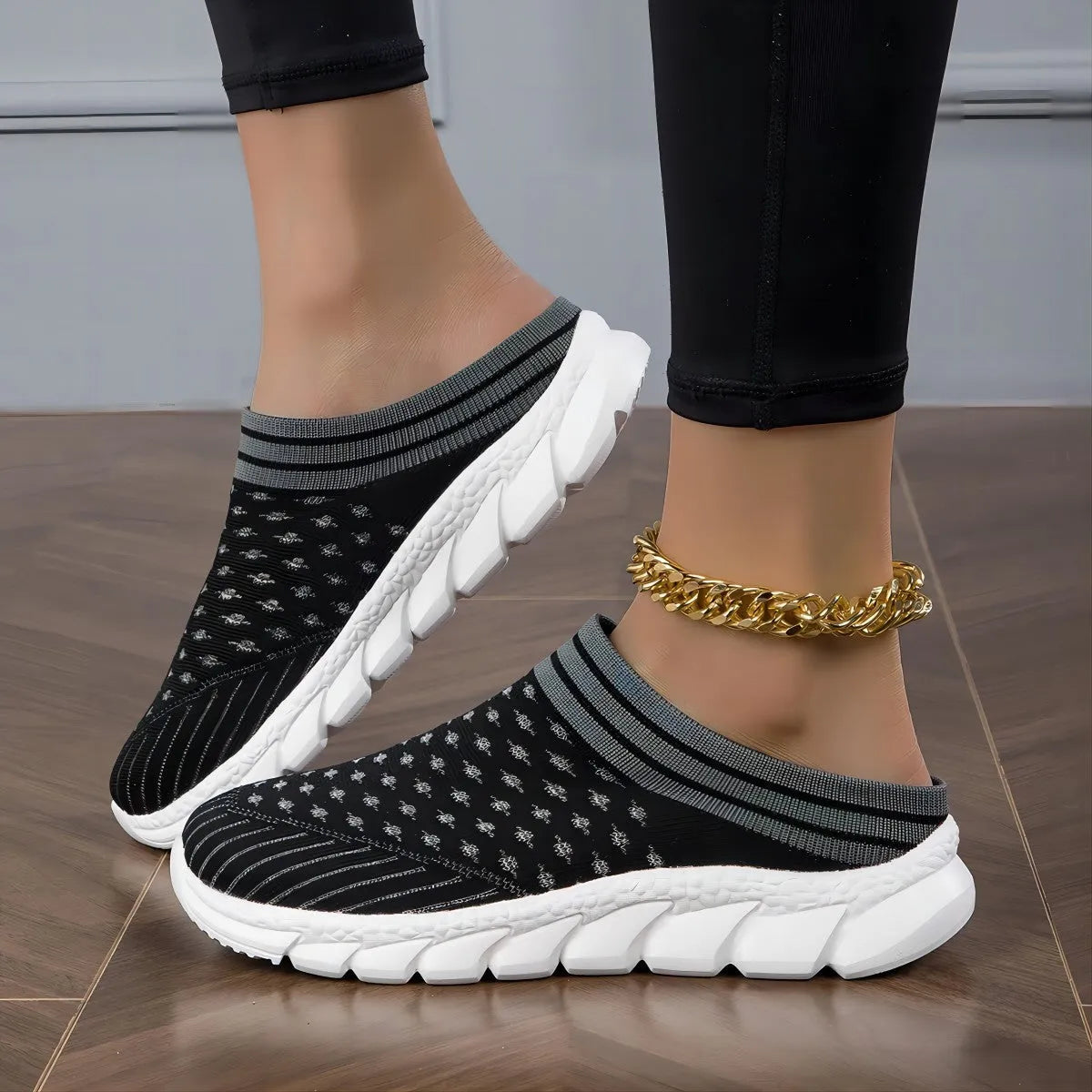 Women's black flyknit semi-slipper sock shoes with striped pattern and hollowed-out sewing lines on a lightweight sole.