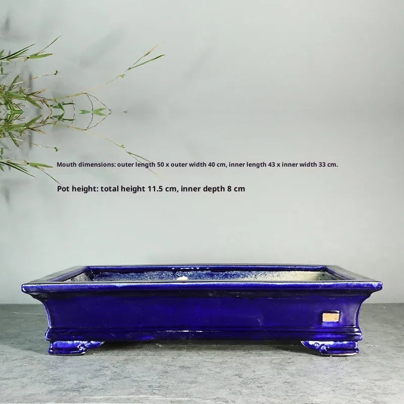 White cracked ceramic bonsai flowerpot with bamboo plant, manual purple sand craft