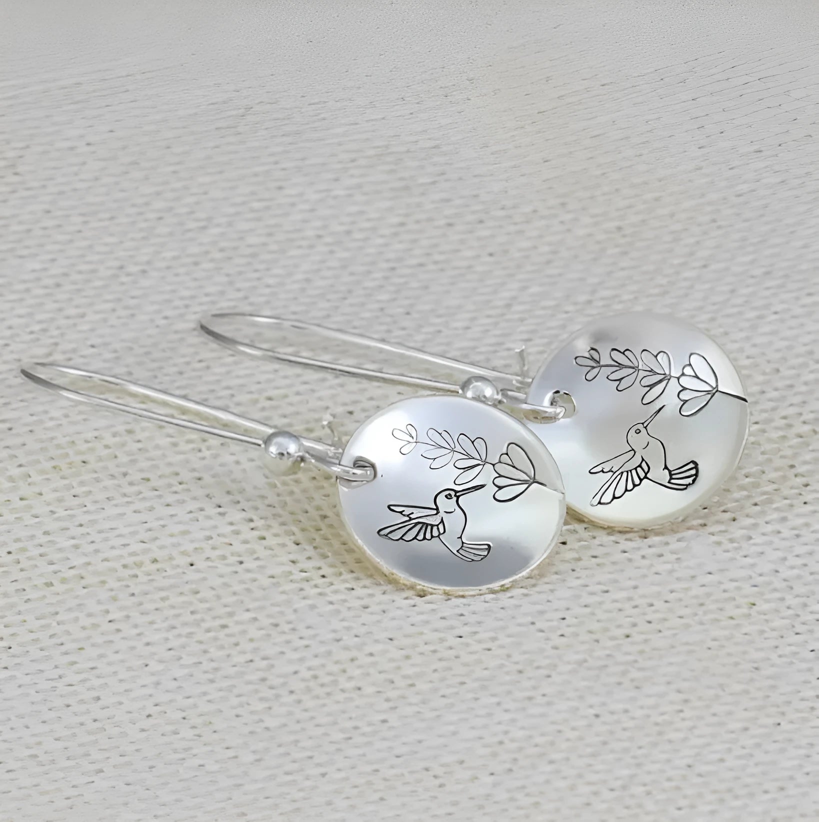 Women's round silver earrings with glossy finish showing bird and flower retro designs