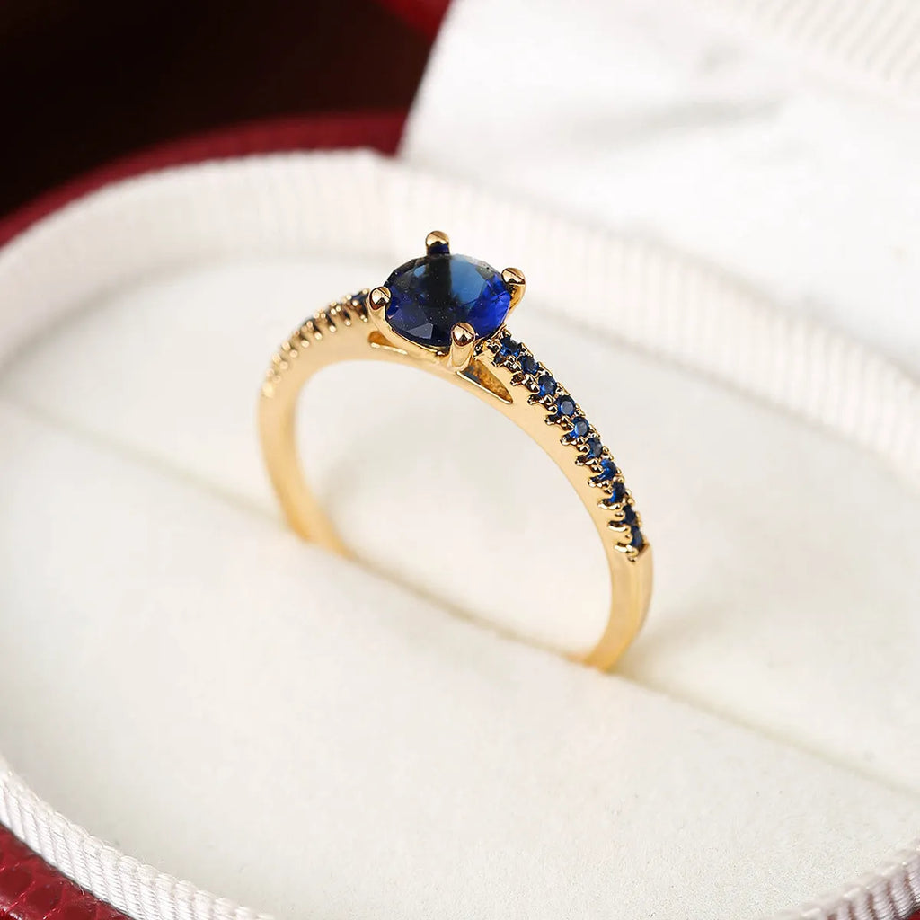 Hexagonal geometric copper ring with zircon electroplating in a gold rose red finish on a hand.