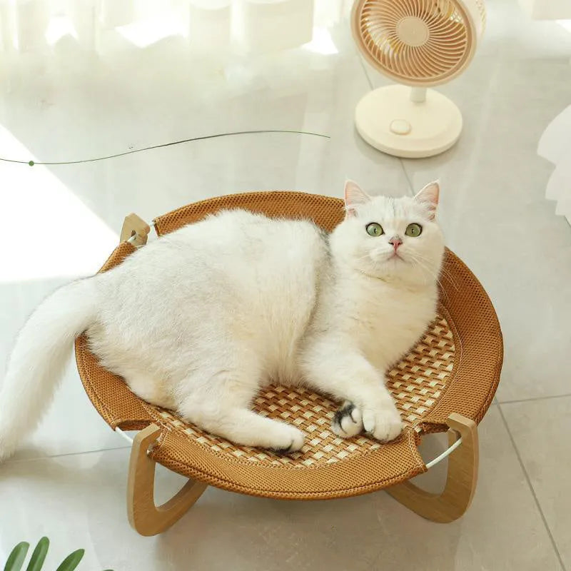Brown square woven rattan raised hammock bed for cats and dogs on a wooden floor.