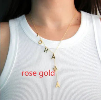 Gold lariat name necklace with bubble letters on adjustable chain, isolated on white background