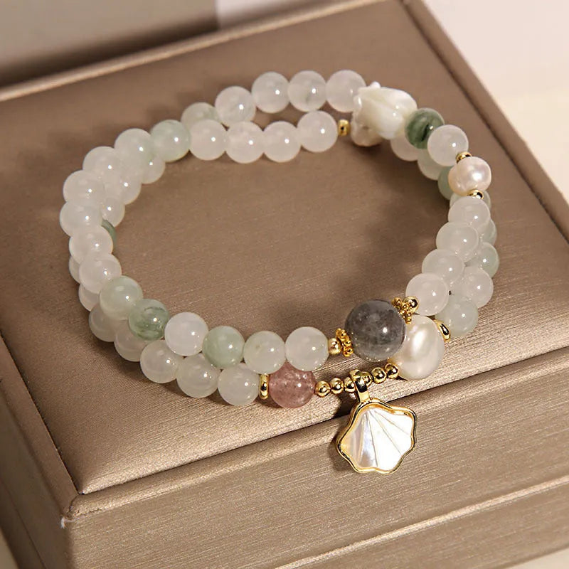 Women's artistic crystal bracelet with a green Tianshan Jade ginkgo leaf pendant and gold-plated accents.