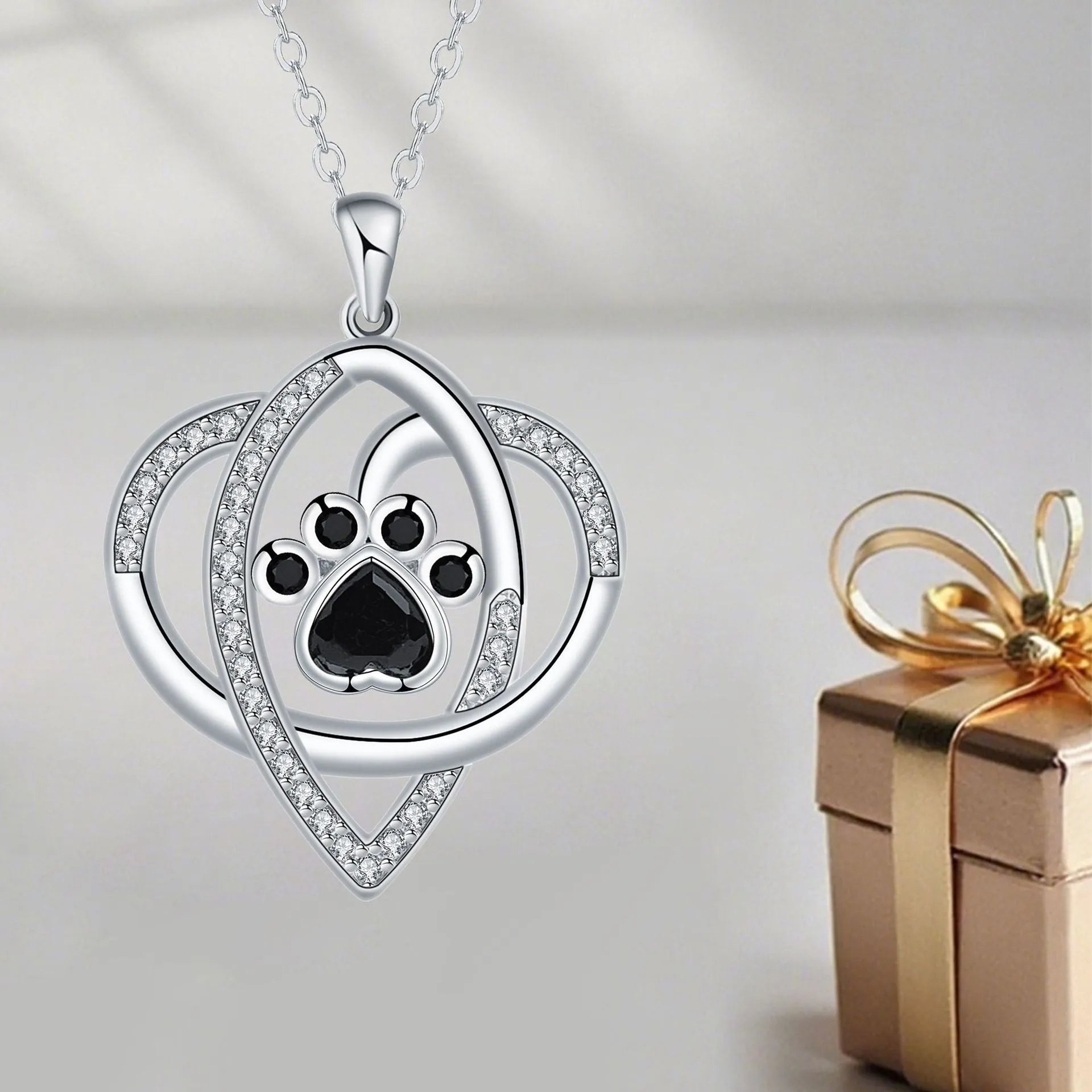 Close-up of a women's copper necklace with a dog paw print pendant on a cross chain.