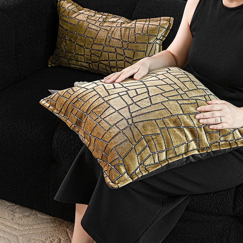 Gold geometric abstract pattern on a square polyester cushion cover with tassel detail.