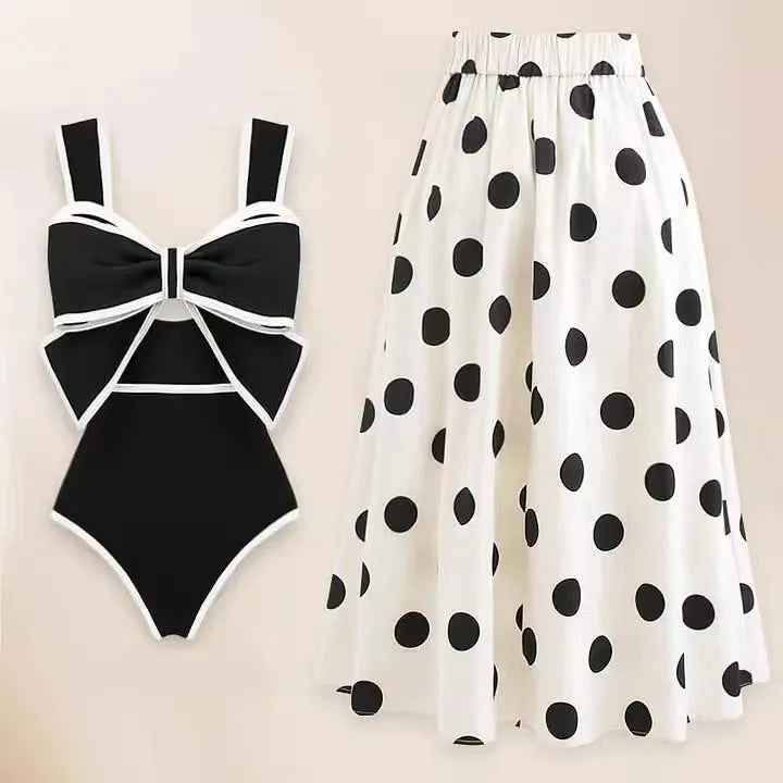 Women's black one-piece swimsuit with a white bow and attached round skirt.