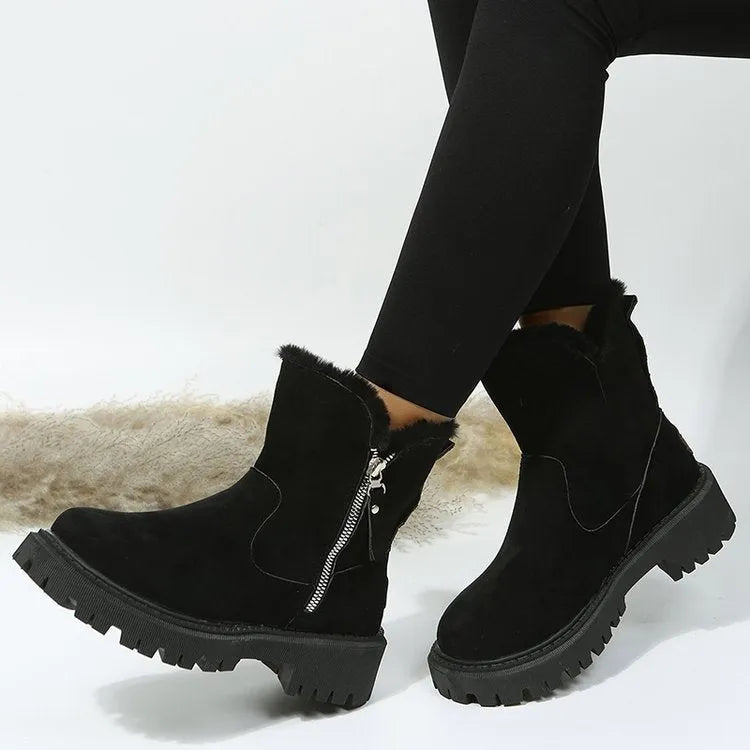 Women's black snow boots with foldable plush tube, suede upper, and rubber sole on winter pavement