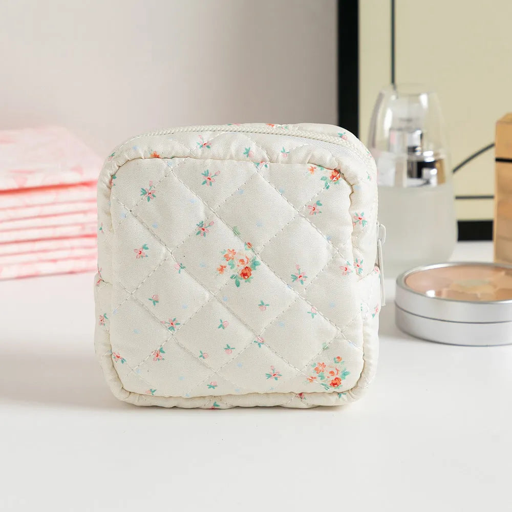 Yellow floral polyester key storage bag with sewing thread detail next to red small flower design variant.