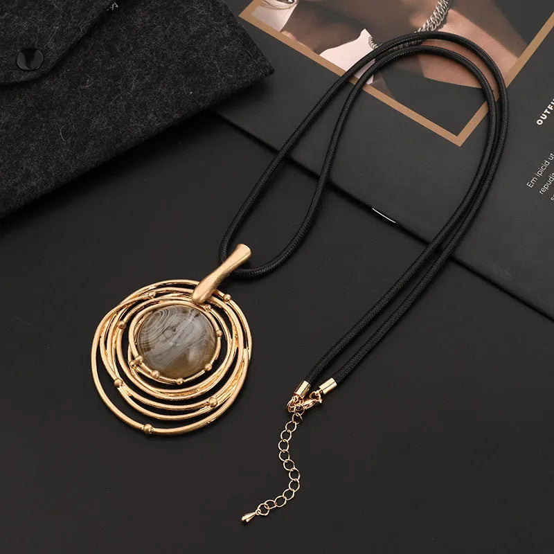 Gold tone geometric plaid pendant on a textured snakeskin wax rope chain necklace, adjustable from 51cm to 80cm.
