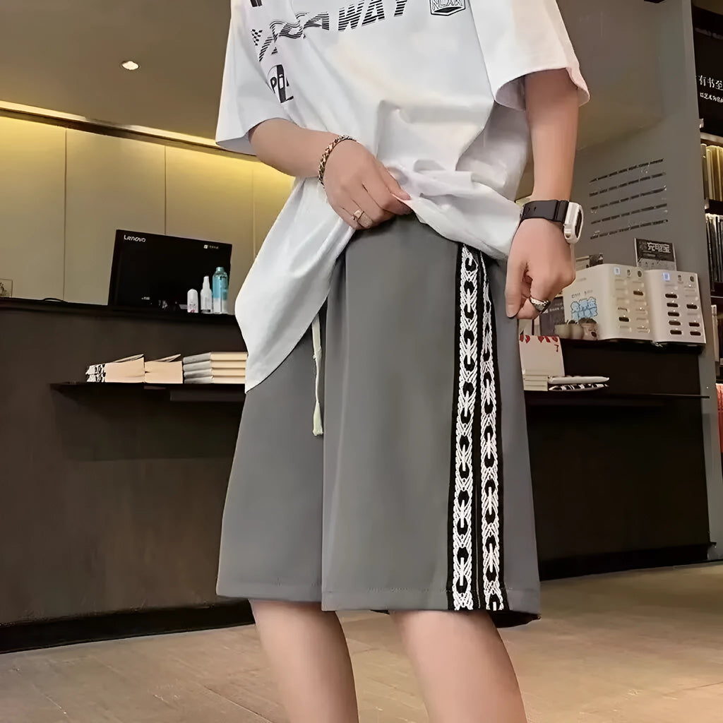 Men's loose black track pants with elastic waistband and baggy leg fit
