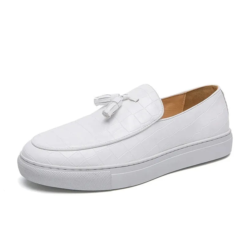 Men's black tassel slip-on sneakers with a round toe and rubber sole on a white background.