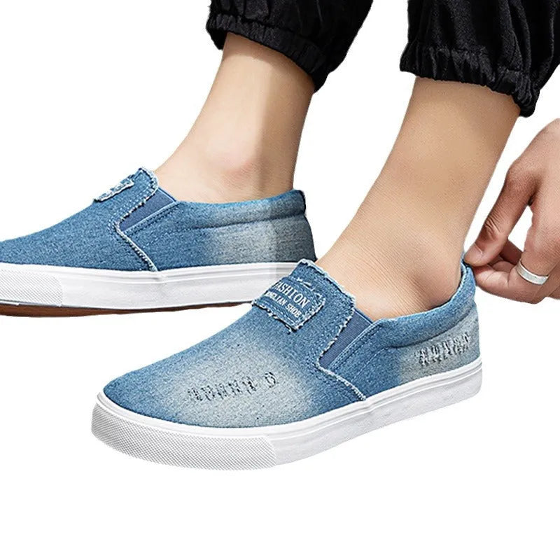 Slip-on canvas work shoes in dark blue with round toe and rubber sole on a plain background