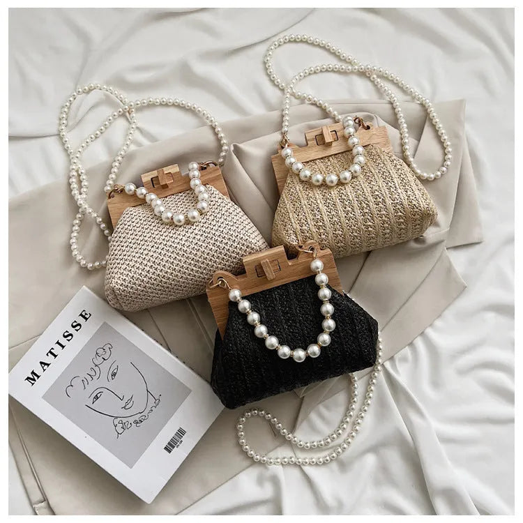 Women's woven straw shoulder bag with pearl chain strap in horizontal square shape showing sandwich pocket detail.