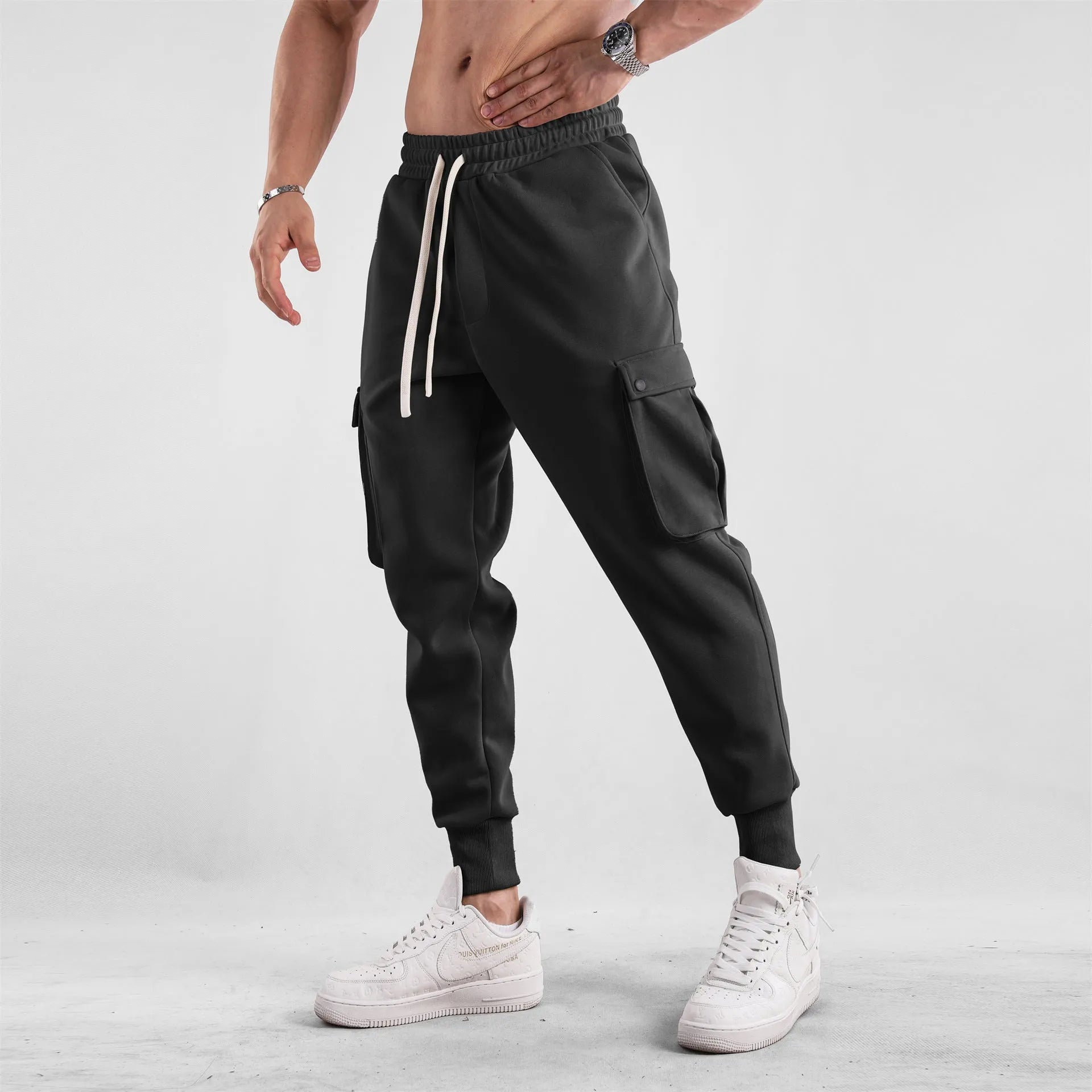 Men's loose-fit light grey cotton sports trousers with ankle tie and side pockets.