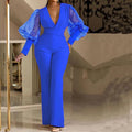 Red women's jumpsuit with mesh stitching on long sleeves, slim fit bodice, wide legs, and elastic waist.