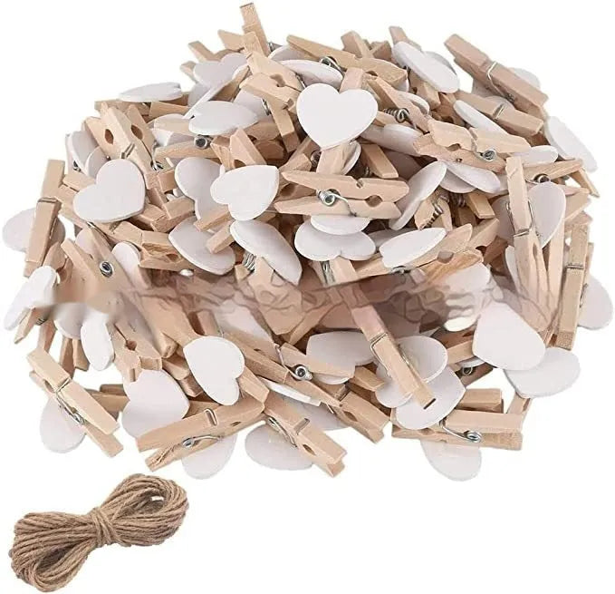 Set of five solid wood heart-shaped clips in different colours on wooden surface
