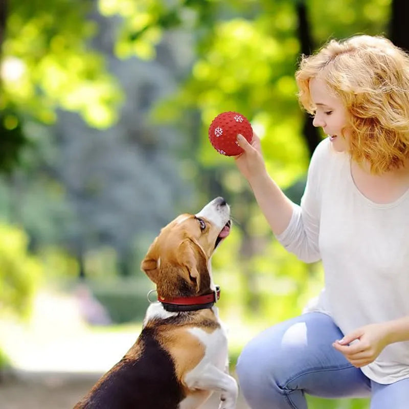 Red dog toy ball with squeaker and air vents, 7 cm diameter, floating on water