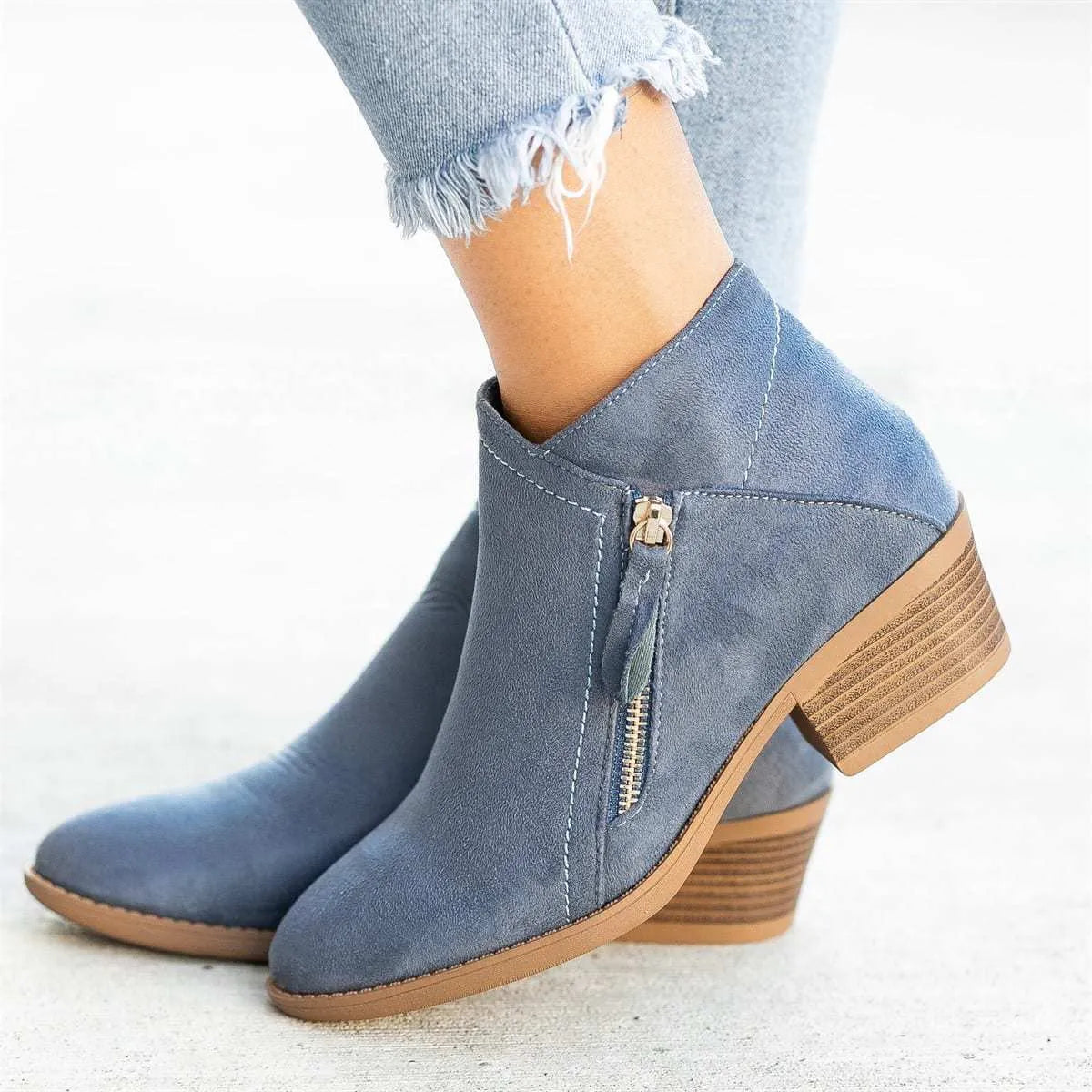 Blue suede women's ankle boots with a chunky heel and side zip closure on a white background.
