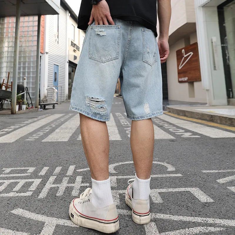 Light blue ripped denim shorts with a loose, straight-leg fit on a neutral background.