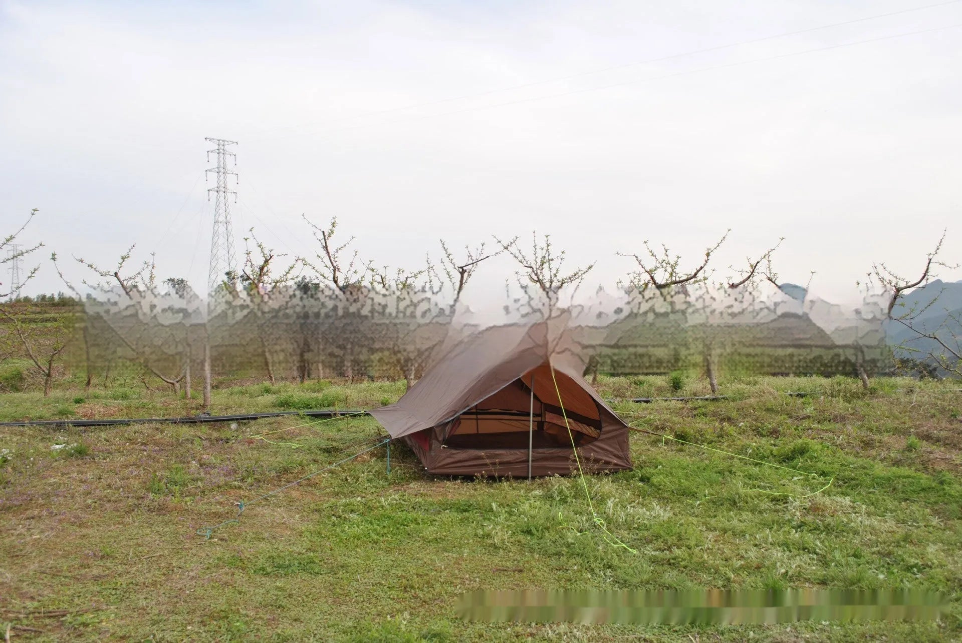 Brown or white A-line hiking tent pitched using hiking canes, showing spacious interior for 2-3 people.