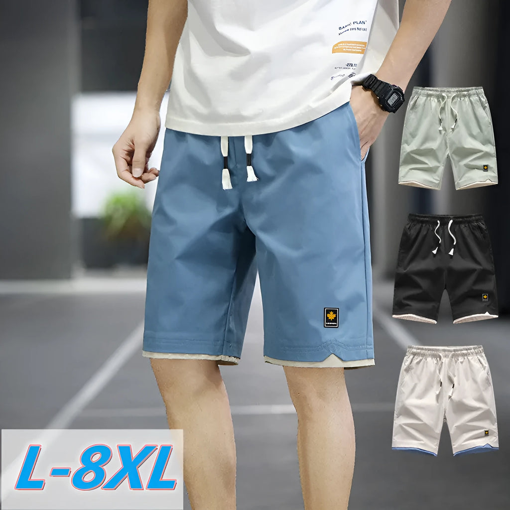 Man modelling loose-fitting straight-leg casual shorts in a solid colour on a beach.
