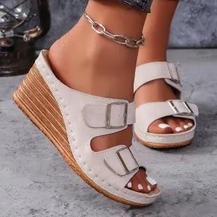 Women's creamy-white beach slippers with an outer wedge belt buckle fastening.