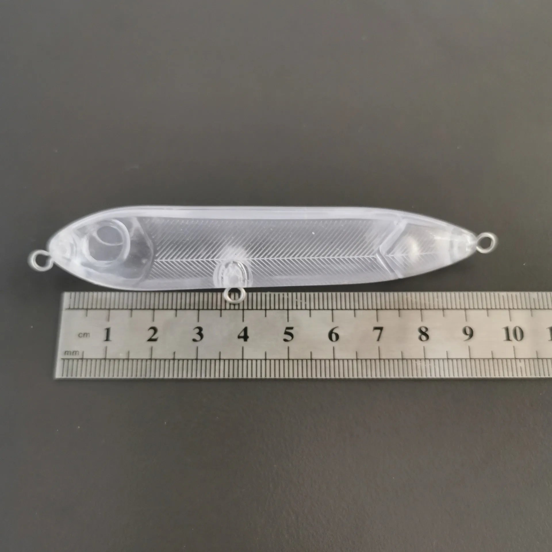 Transparent 9.5cm long ABS plastic blank fishing lure body with detailed shape and eye holes.