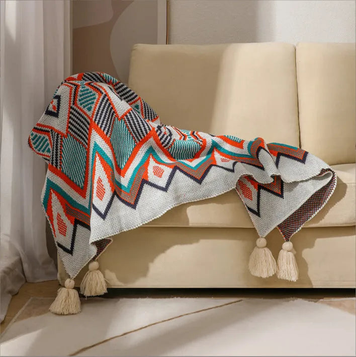 Acrylic sofa blanket with tassel fringe in geometric pattern, showing 130 cm width measurement