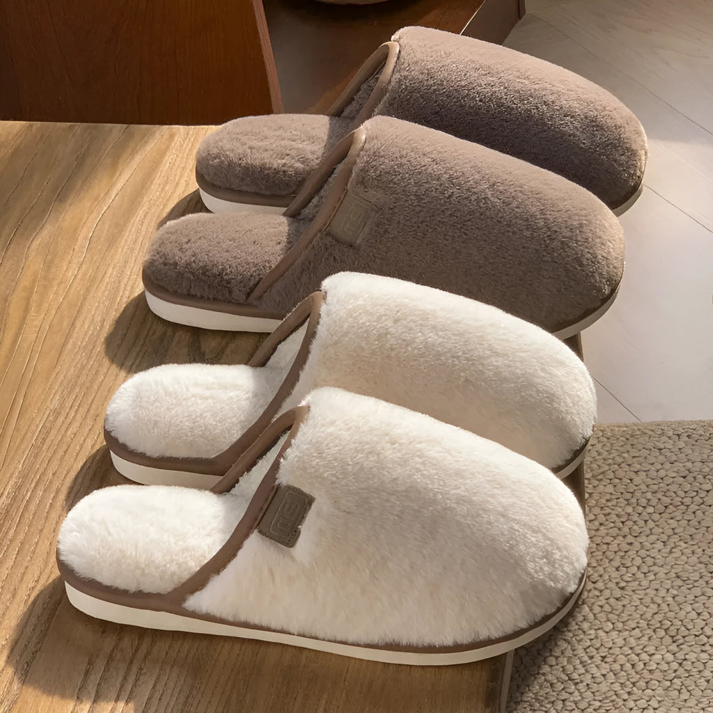 Solid colour PVC plush winter house slippers on a wooden floor.