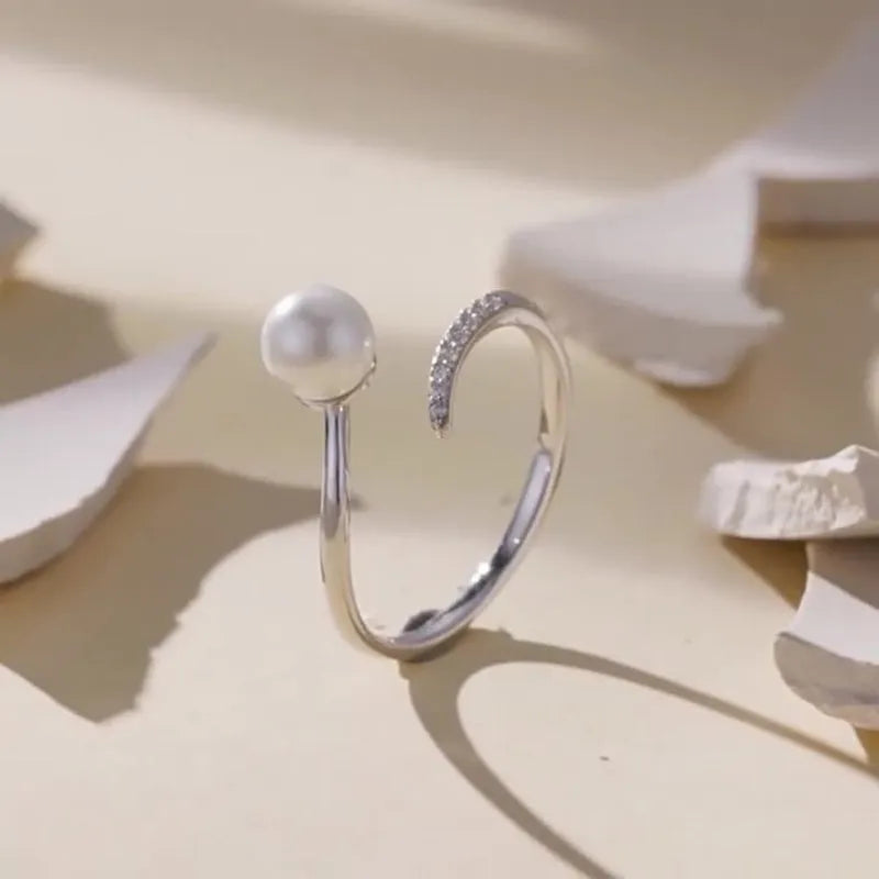 Open loop adjustable sterling silver ring with a white shell pearl.