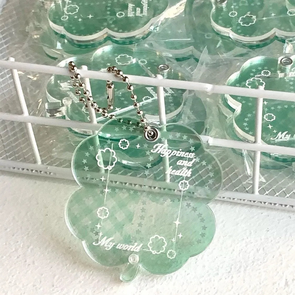 Acrylic four-leaf clover phone pendant keychain on a ring in blue, green, or mint.