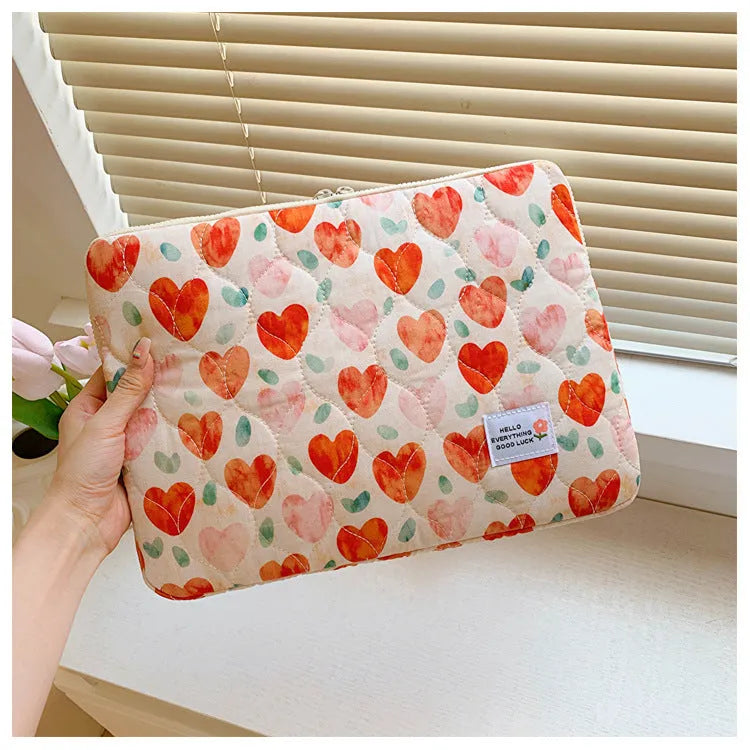 Floral print cloth laptop bag in green flower, pink floral, red flower, and red heart designs, showing three size options.