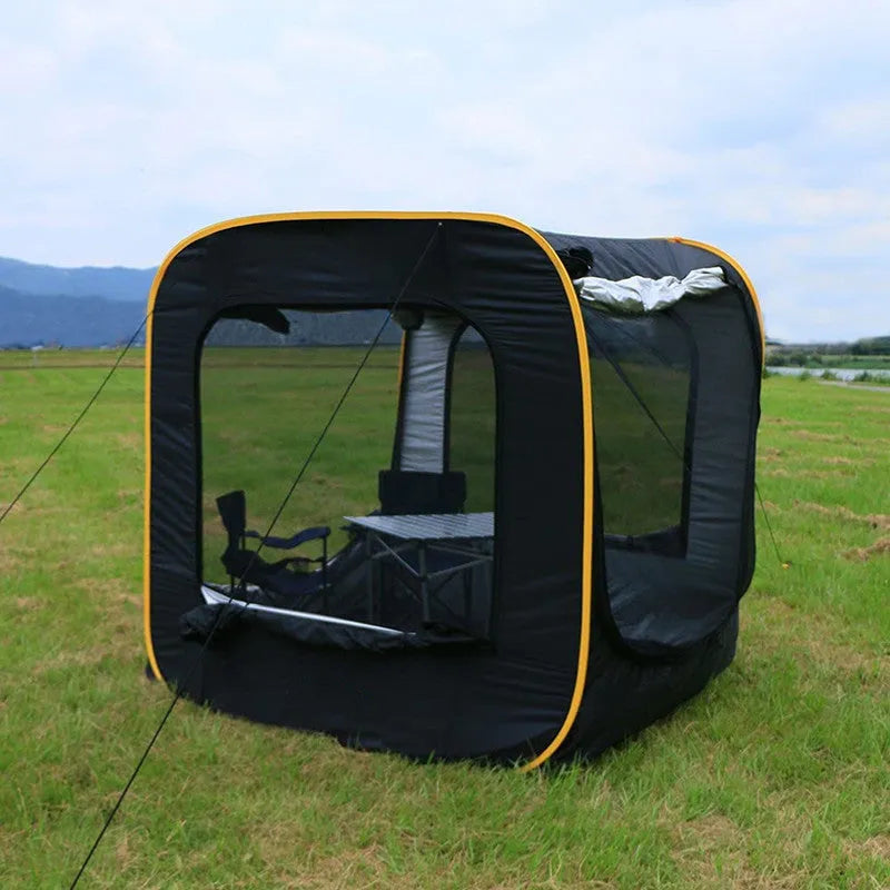 Black pop-up tailgate tent unfolded next to a car, showing its cubic 200cm shape and quick-throw design.