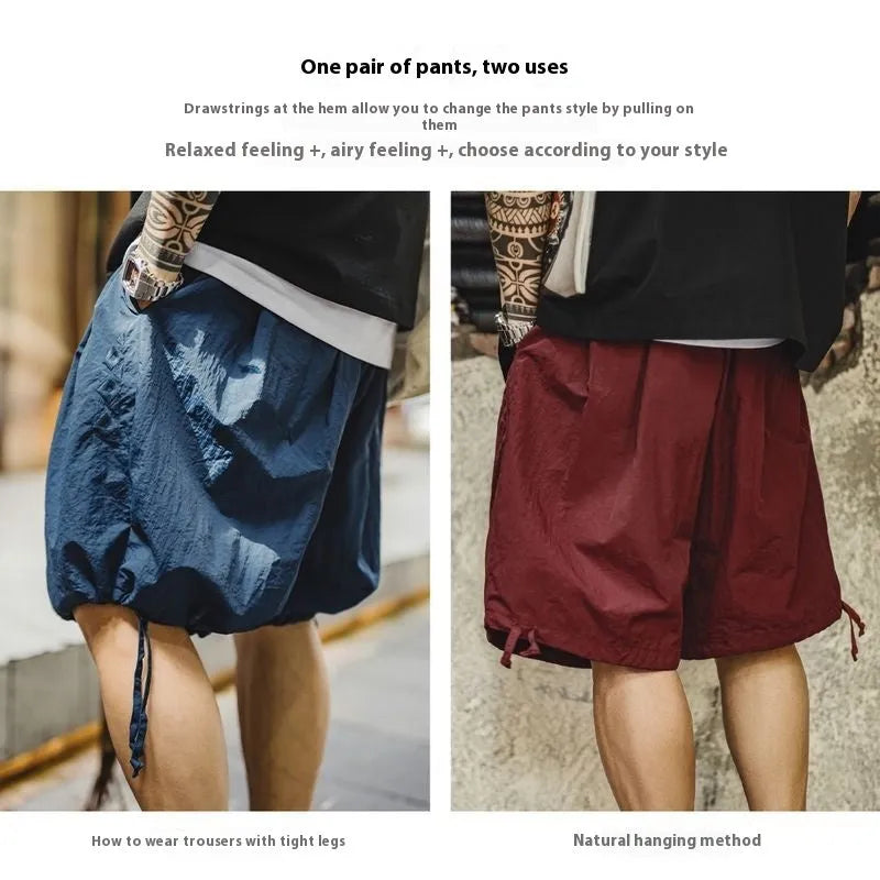 Prussian blue men's loose-fit nylon shorts with embroidery on a summer beach background.