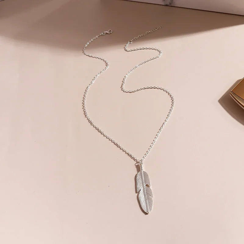 Retro feather tassel necklace for women in gold with geometric leaf pendant and feather tassel on alloy chain