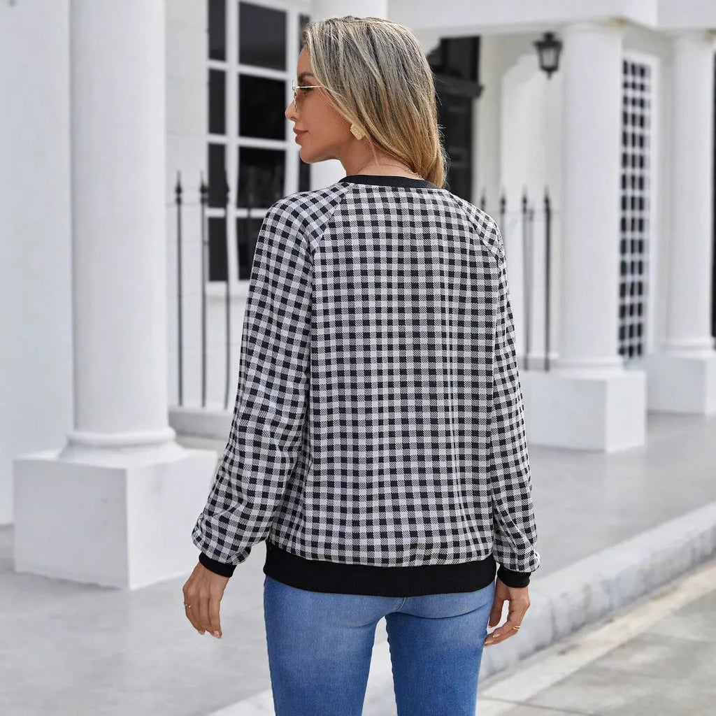 Black long sleeve pullover sweater with plaid pattern and printing detail showing front view