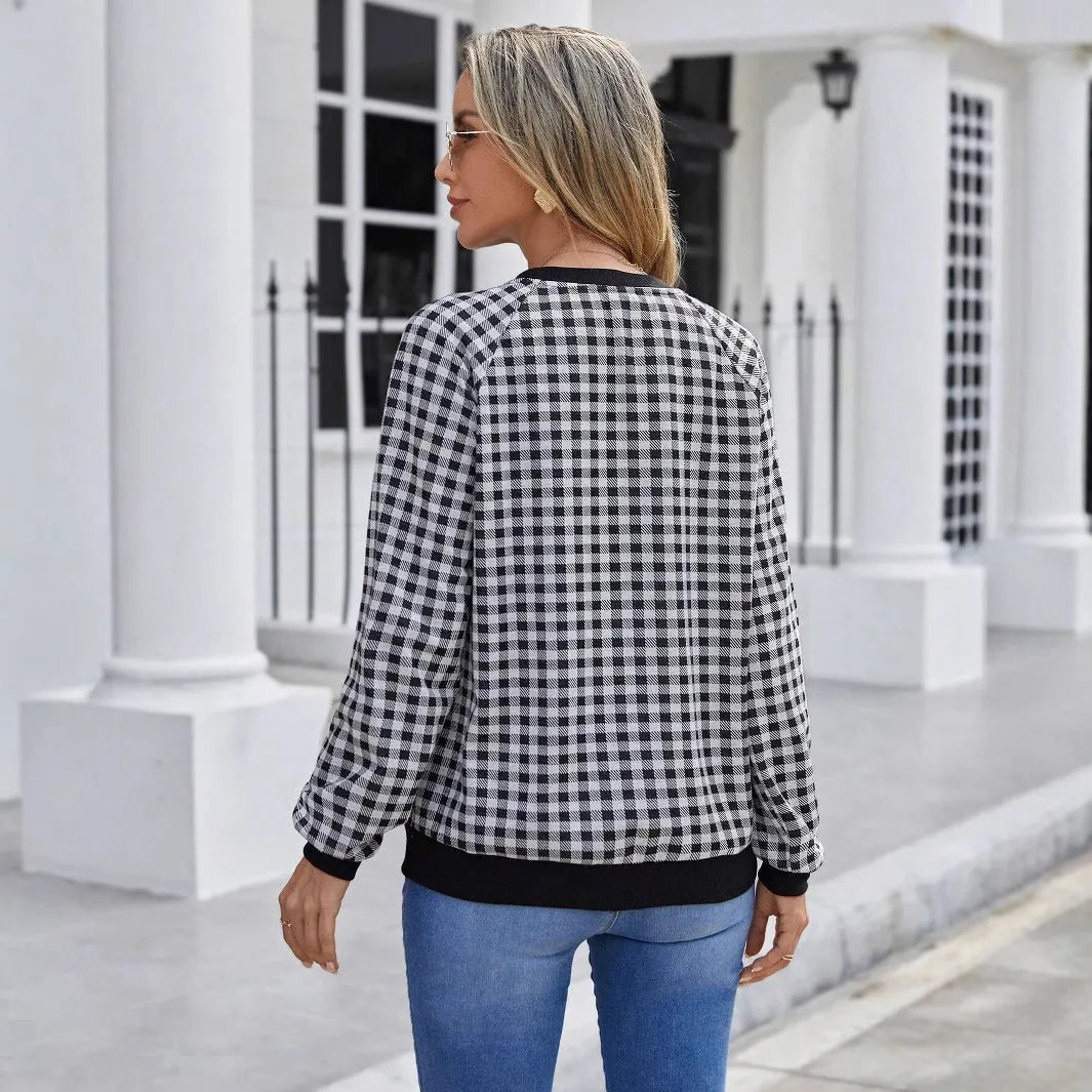 Black long sleeve pullover sweater with plaid pattern and printing detail showing front view